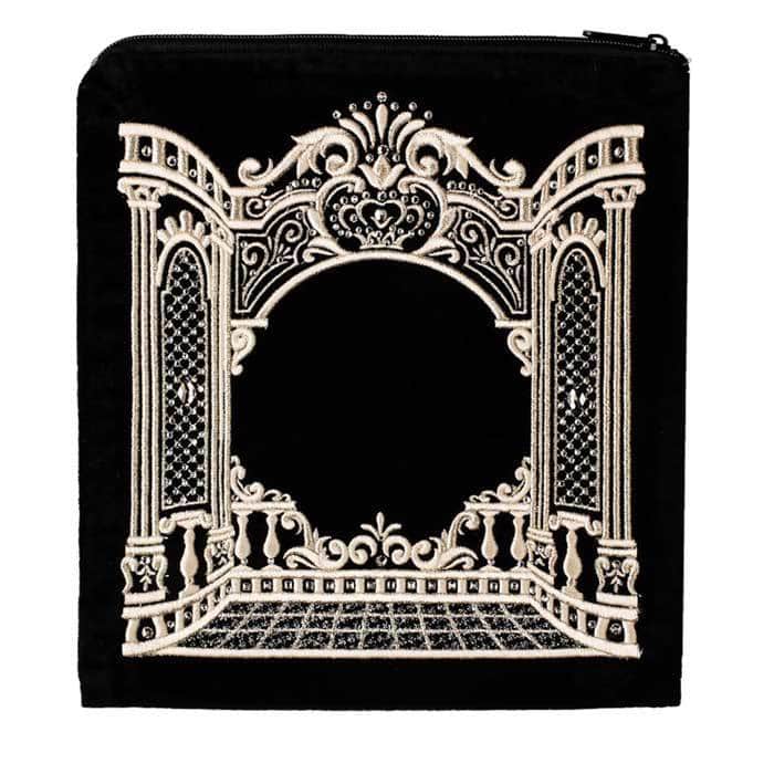 תקריב של נרתיק שחור עם רוכסן הכולל עיצוב רקום זהב מורכב ומעוטר המתאר במת תיאטרון וינטג', המציג אלמנטים של שקית לתפילין שער ההיכל.